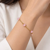 Pulseira dourada com contas rosadas ovais e fecho delicado