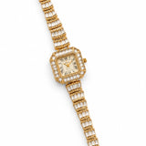 Relógio dourado com mostrador retangular e pulseira metálica cravejada