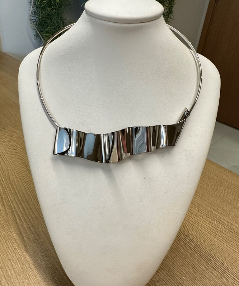 Colar prateado com franja de placas retangulares, fecho lateral.