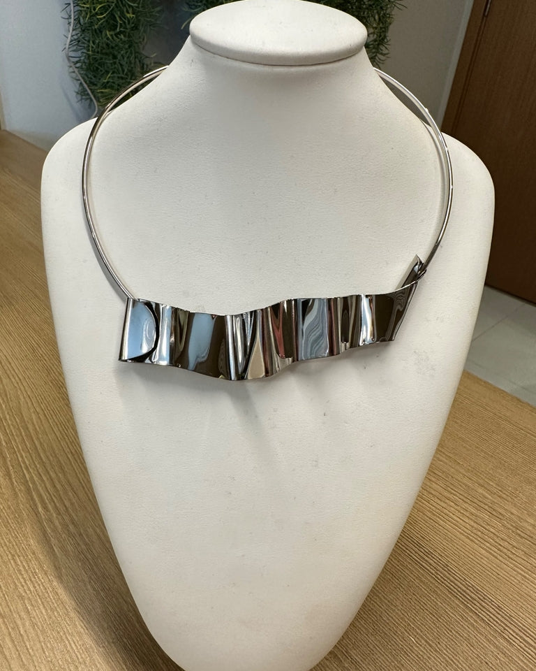 Colar prateado com franja de placas retangulares, fecho lateral.