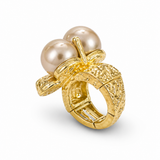 Anel dourado com três pérolas e base vazada texturizada.