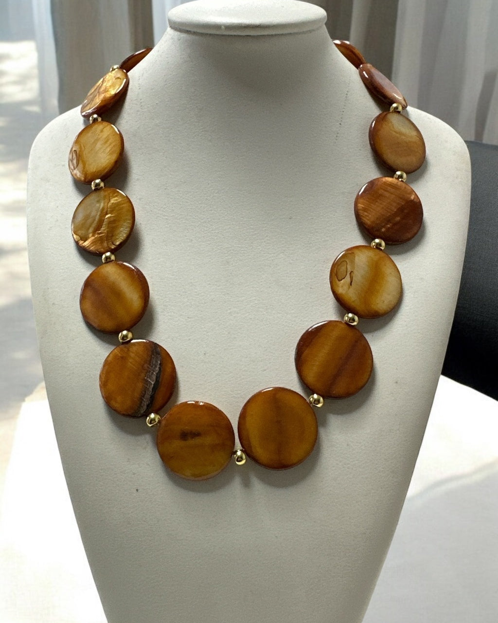 Colar com contas ovais marrons e acabamento dourado