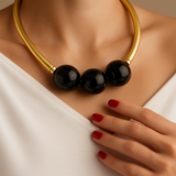 Colar gargantilha dourado com contas pretas brilhantes em formato de bolas