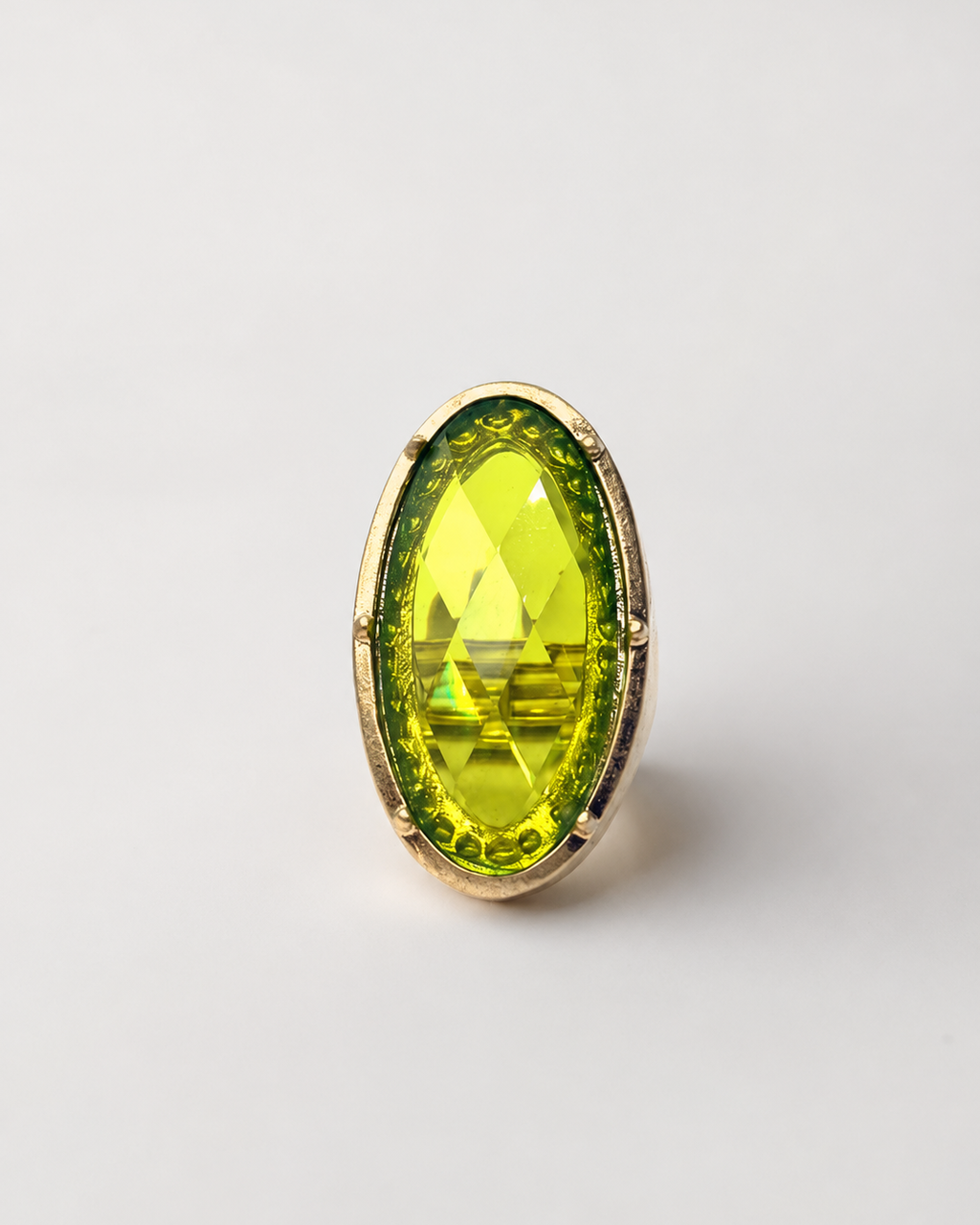 Anel Jamaica com pedra oval verde-amarelada e aro dourado