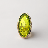 Anel Jamaica com pedra oval verde-amarelada e aro dourado