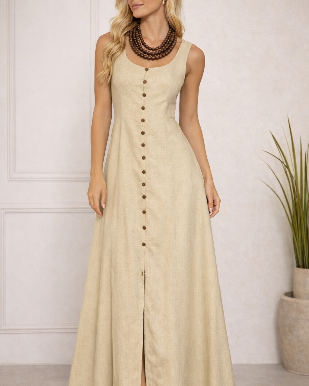 Vestido longo bege com alças largas, botões frontais e fenda na barra.