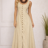Vestido longo bege com alças largas, botões frontais e fenda na barra.