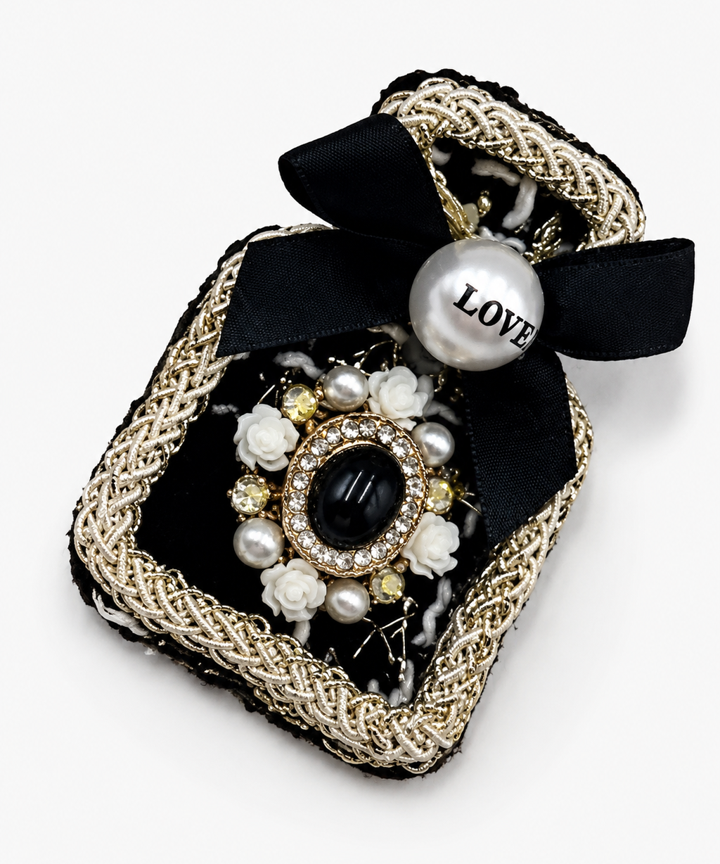 Broche preta com laço, correntes douradas e aplicação de flores de pérolas LOVE