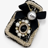 Broche preta com laço, correntes douradas e aplicação de flores de pérolas LOVE