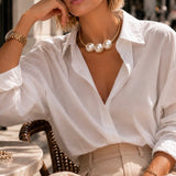 Colar choker dourado com três pérolas brancas na gola