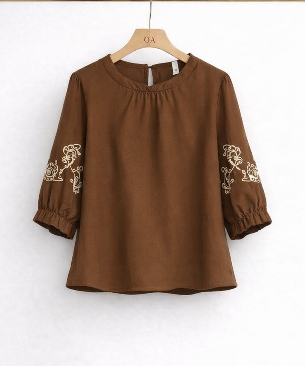 Blusa marrom de gola franzida, mangas bufantes com bordado branco, vista frontal