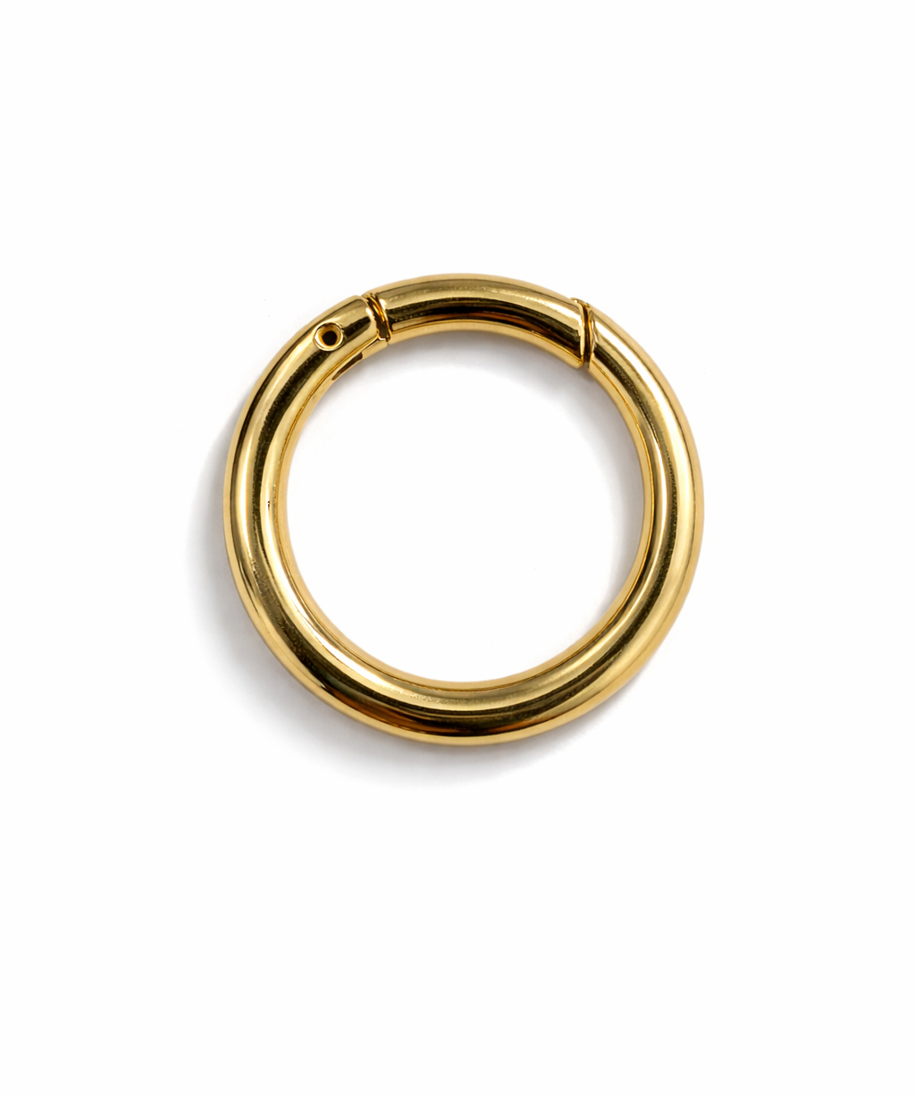 Mosquetão dourado em formato de argola com trava