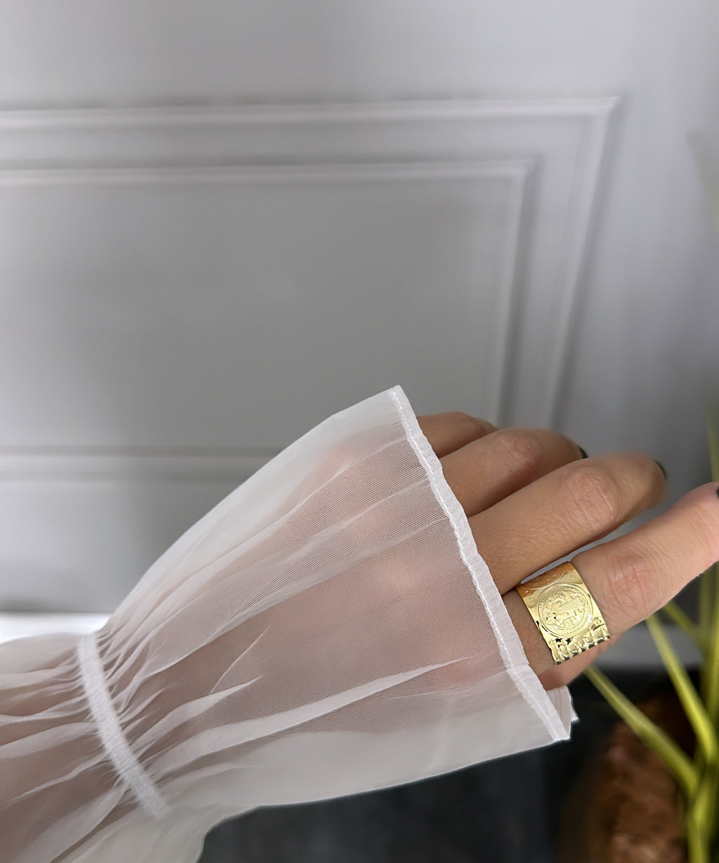 Anel dourado com símbolo de São Bento no aro