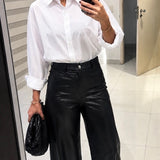 Calça preta de cintura alta, modelagem ampla, com bolsos e zíper frontal