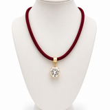 Colar com cordão vinho e pingente oval cravejado com zircônias, metal dourado