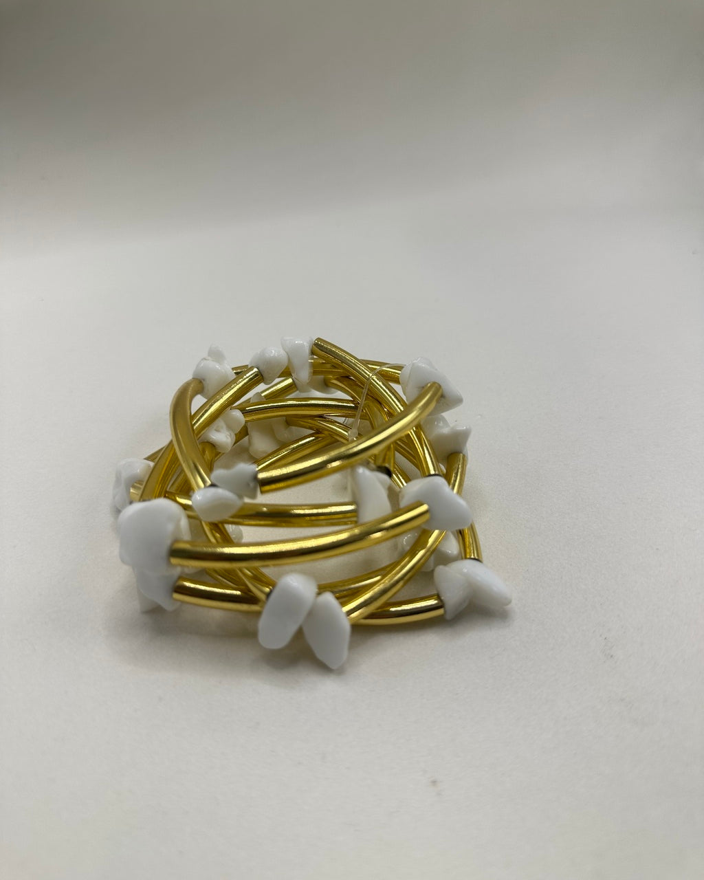 Pulseira folheada dourada com pedras brancas em formato de gota e elos curvos