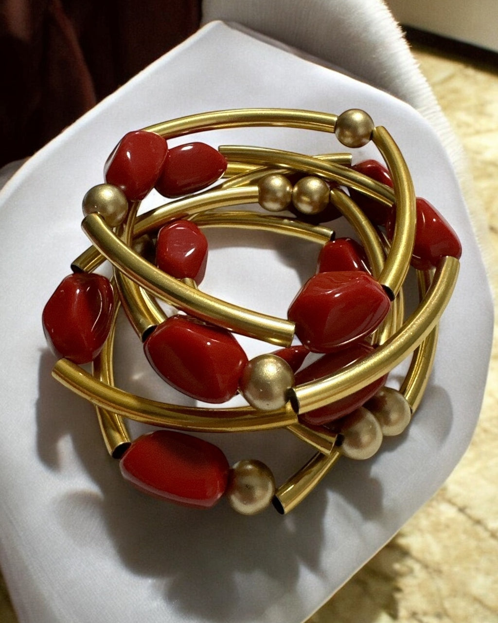 Pulseira de argolas douradas com contas vermelhas e esferas douradas