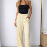 Calça pantalona amarela clara com cós elástico e caimento amplo