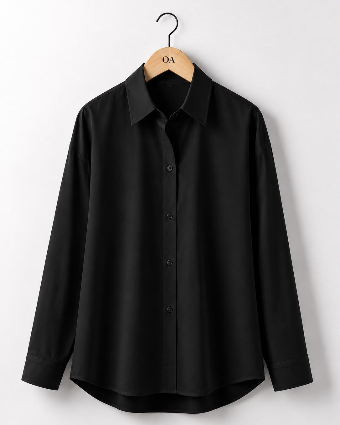 Camisa preta de manga longa, botões frontais e gola clássica.