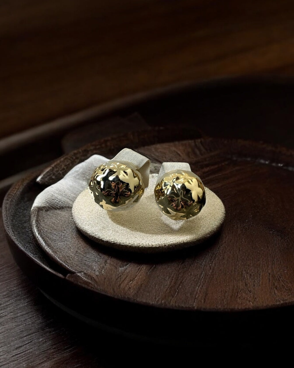 Par de brincos de metal dourado com esfera e padrão detalhado, formato de tarraxa