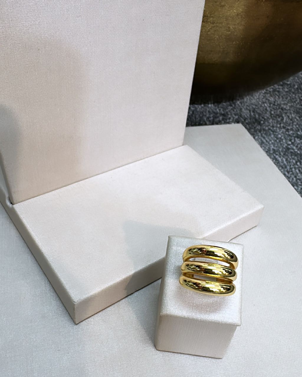Anel Meggie dourado com três faixas curvas e acabamento brilhante