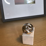 Anel prateado com design ondulado em metal arredondado