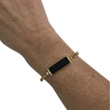 Pulseira com fecho e placa retangular preta, corrente dourada
