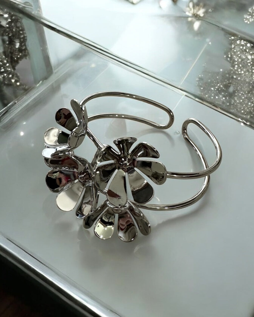Pulseira prateada com argolas e pingentes de flor com pedras escuras