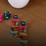 Brinco com pedras retangulares coloridas, em verde, rosa, azul e vermelho, estilo pendente