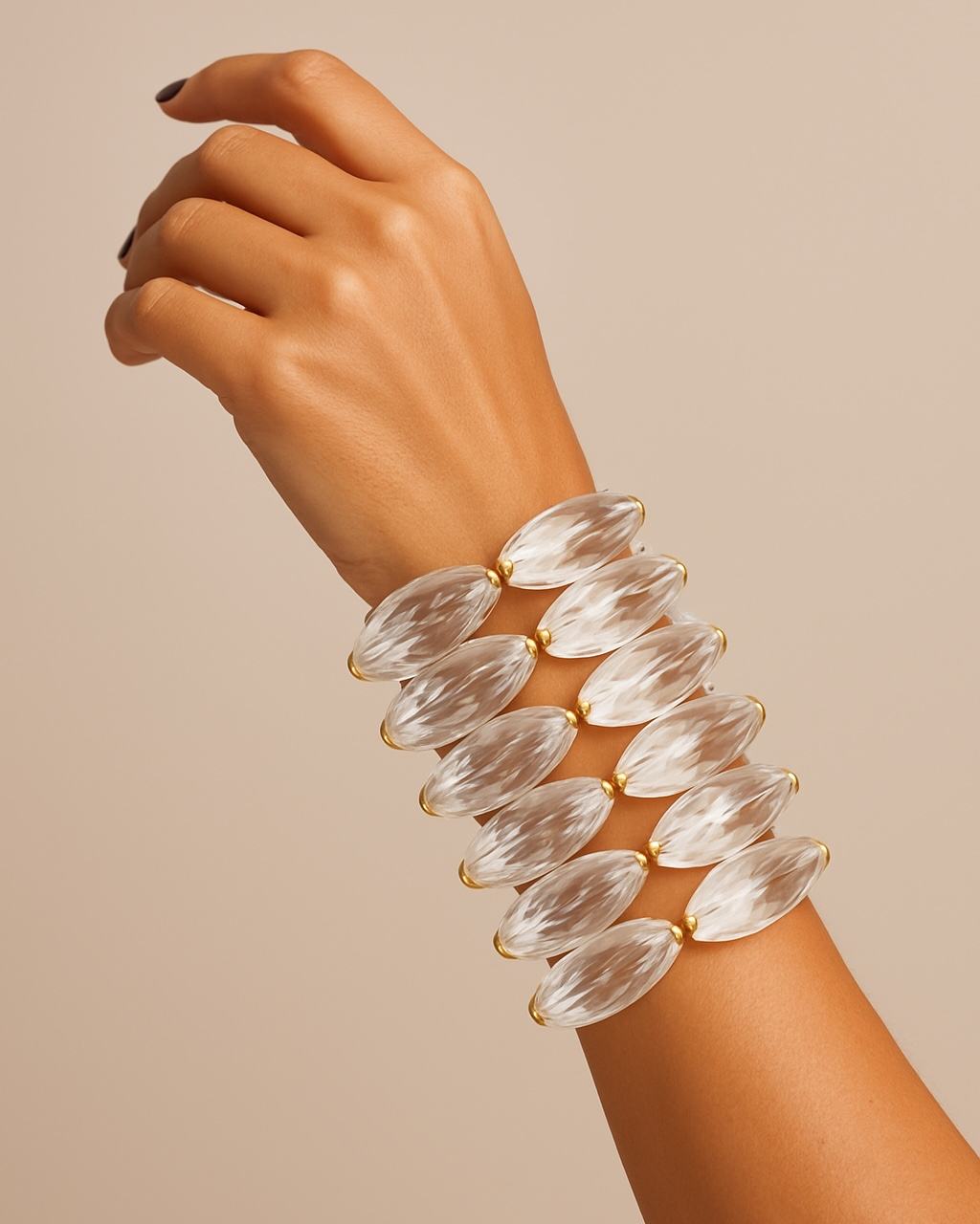 Pulseira de contas ovais transparentes com fecho dourado e detalhes em metal