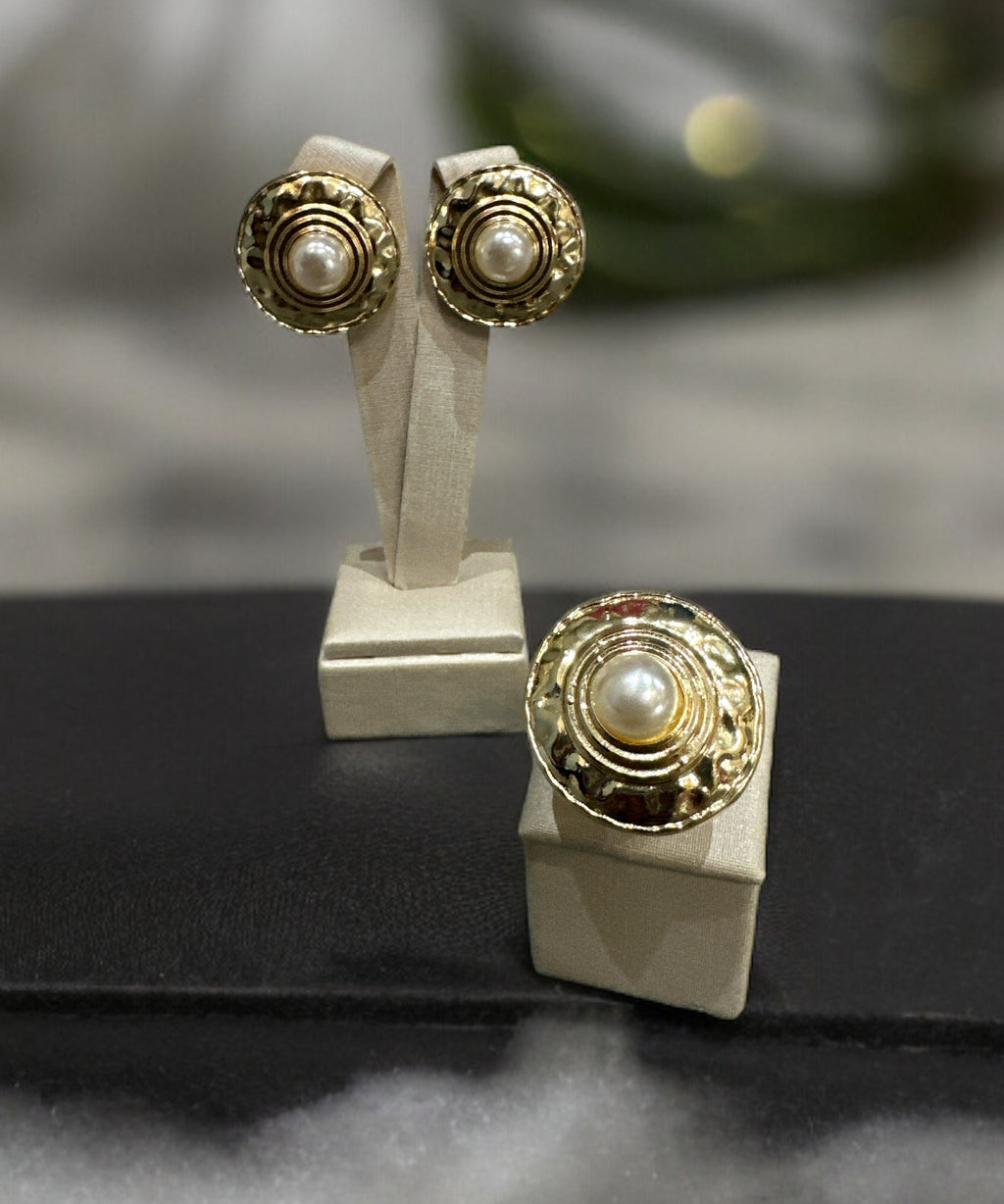 Anel dourado com detalhes circulares no aro e base quadrada
