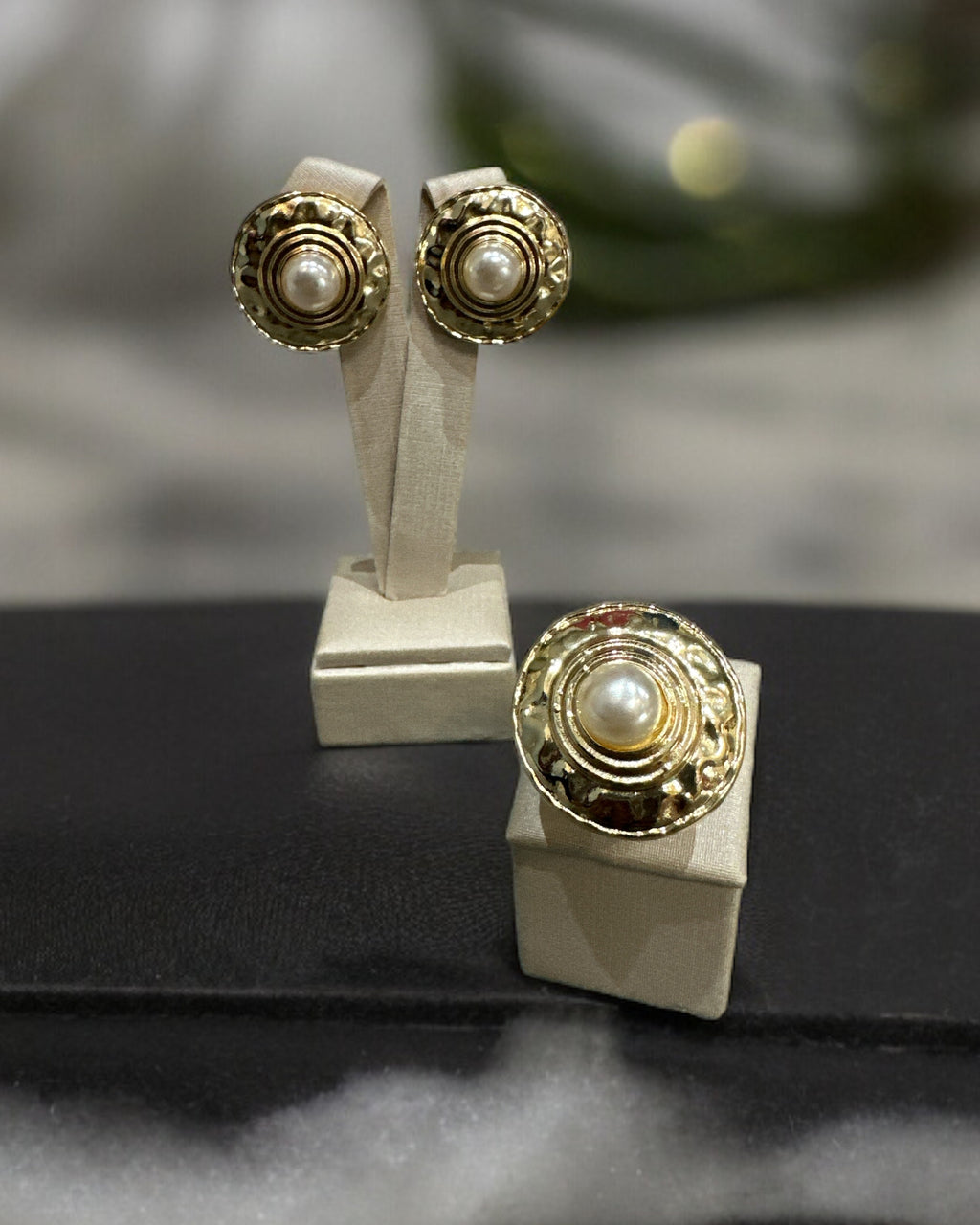 Anel dourado com detalhes circulares no aro e base quadrada