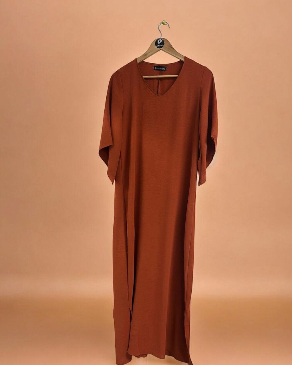 Vestido longo ferrugem com decote V e mangas amplas, caimento solto.