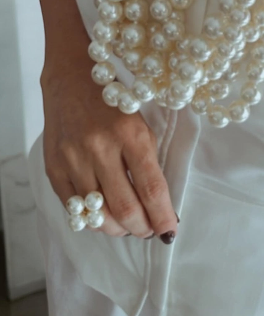 Anel Times com pérolas brancas e detalhe em formato de flor