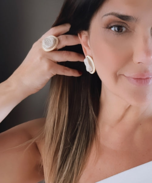 Brinco redondo off-white com textura floral, detalhe no lóbulo