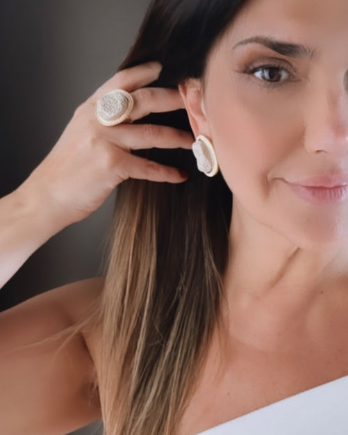 Brinco redondo off-white com textura floral, detalhe no lóbulo
