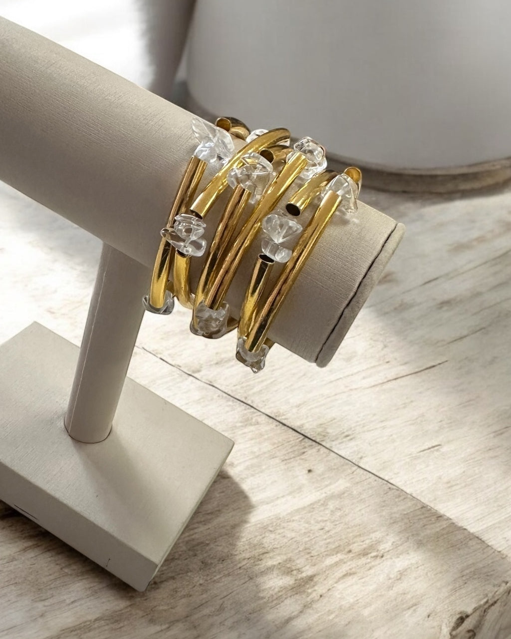 Pulseira dourada com pedras transparentes em hastes trançadas