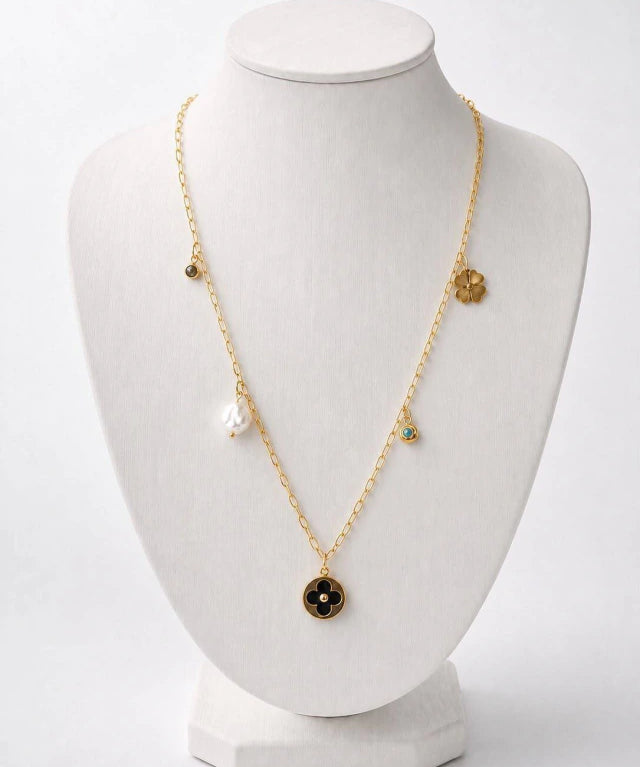 Colar Cleef com corrente dourada e pingente preto em forma de trevo
