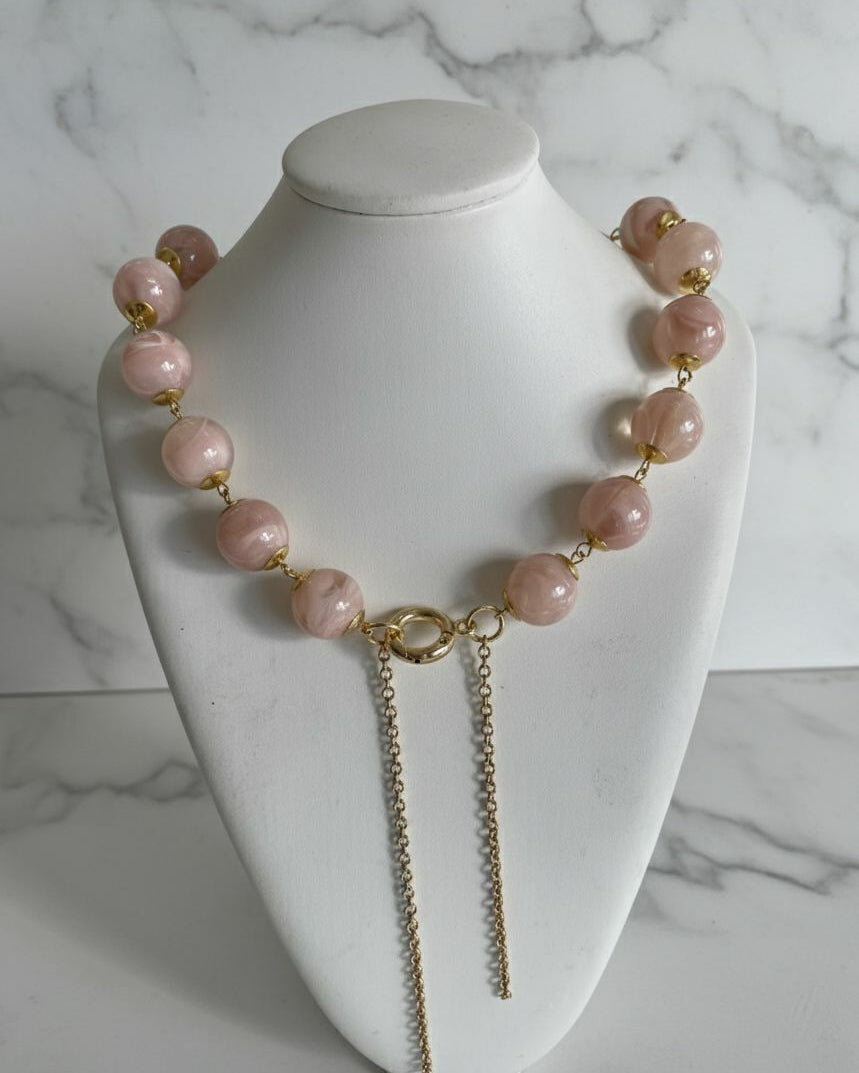 Colar Gloria Slim com contas rosa suave e fecho dourado, duas correntes pendentes.
