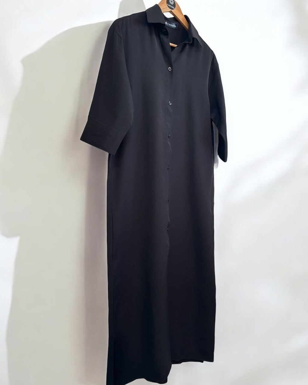 Camisa longa chemise escura em tecido liso, com gola e botões, manga curta