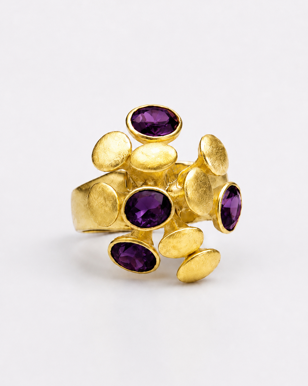 Anel dourado com pedras violeta em formato oval