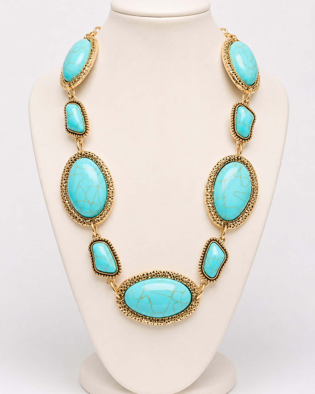 Colar de pedras turquesa em formatos oval e gota com acabamento dourado, em colarinho.