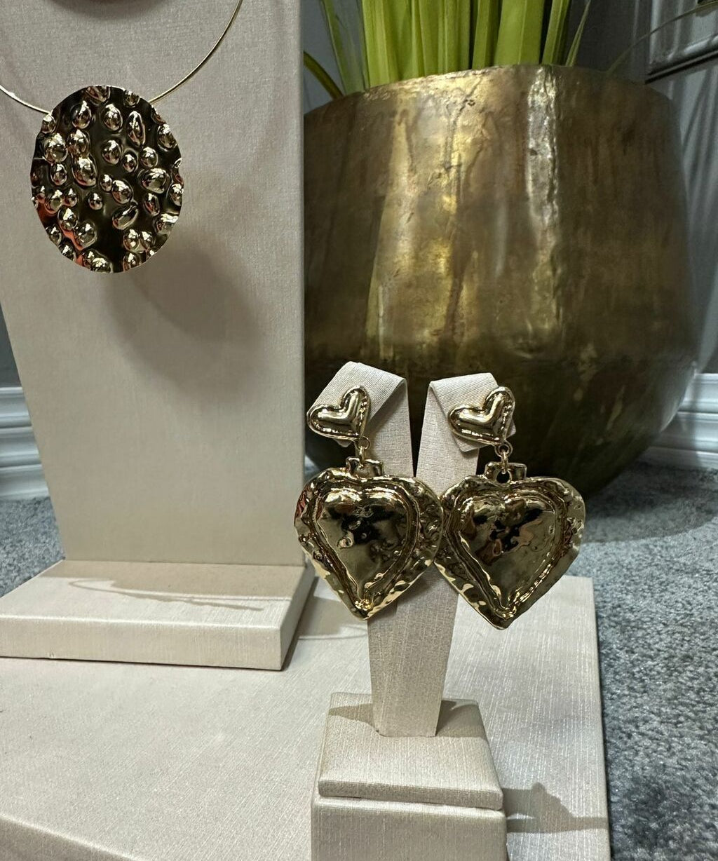 Par de brincos com pingentes de corações, metal prateado com detalhe escuro.