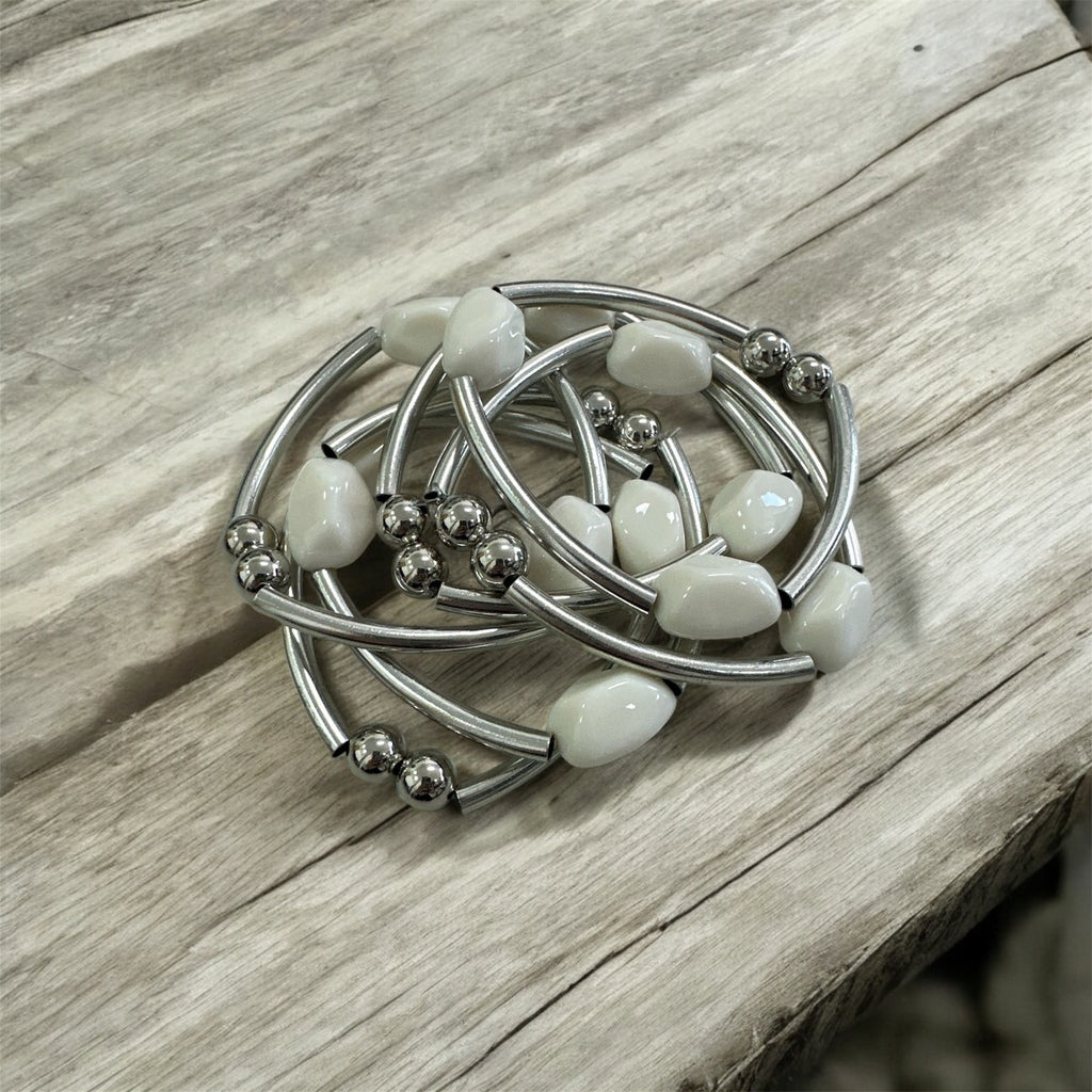 Pulseira de argolas prateadas com contas brancas e pedras brilhantes
