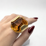 Anel Beta com pedra amarela translúcida e aro dourado quadrado