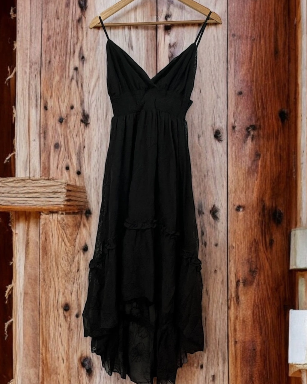 Vestido preto com alças finas, decote V franzido e barra irregular com babados