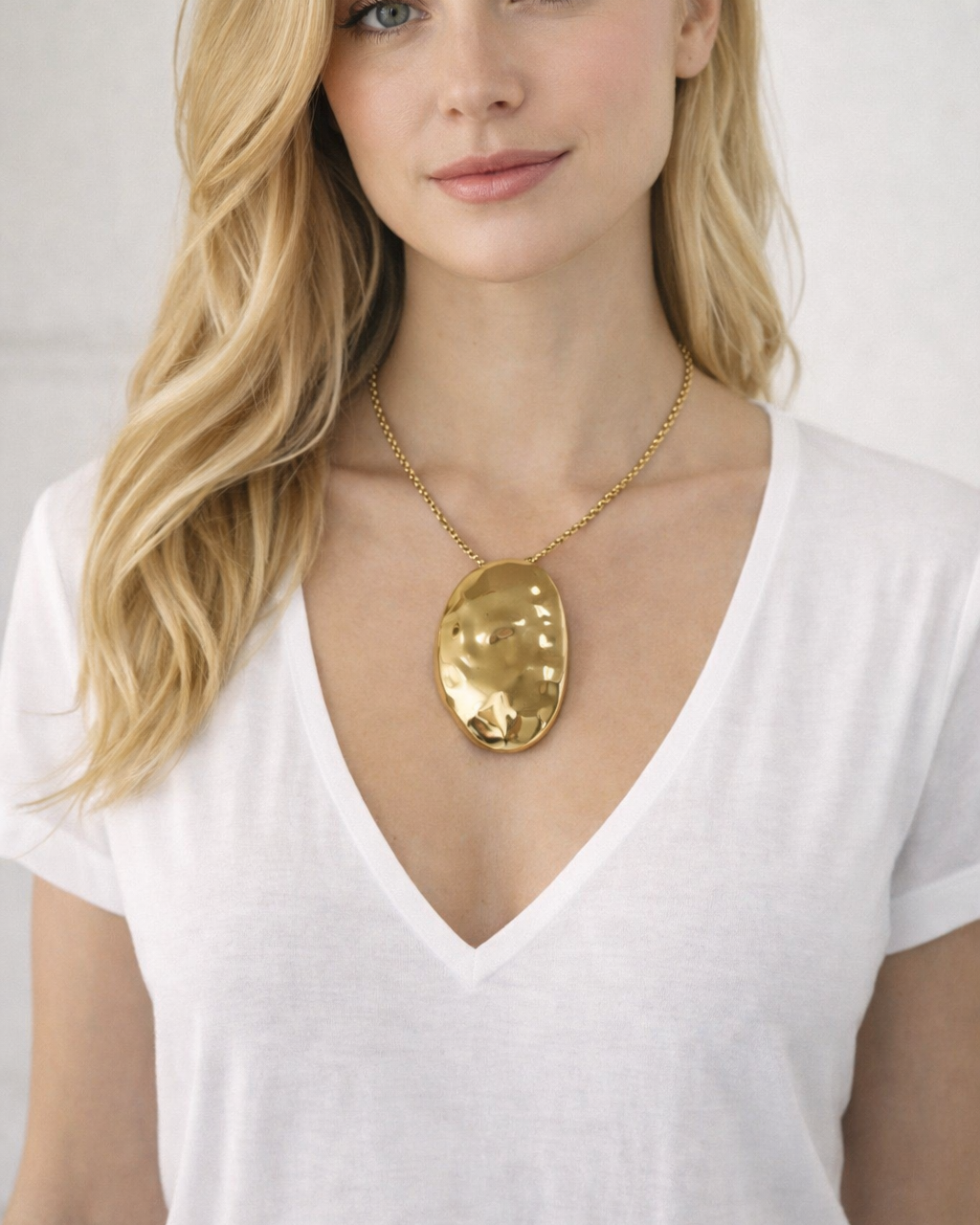 Colar com pingente oval dourado em metal liso, corrente fina ajustável
