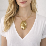 Colar com pingente oval dourado em metal liso, corrente fina ajustável