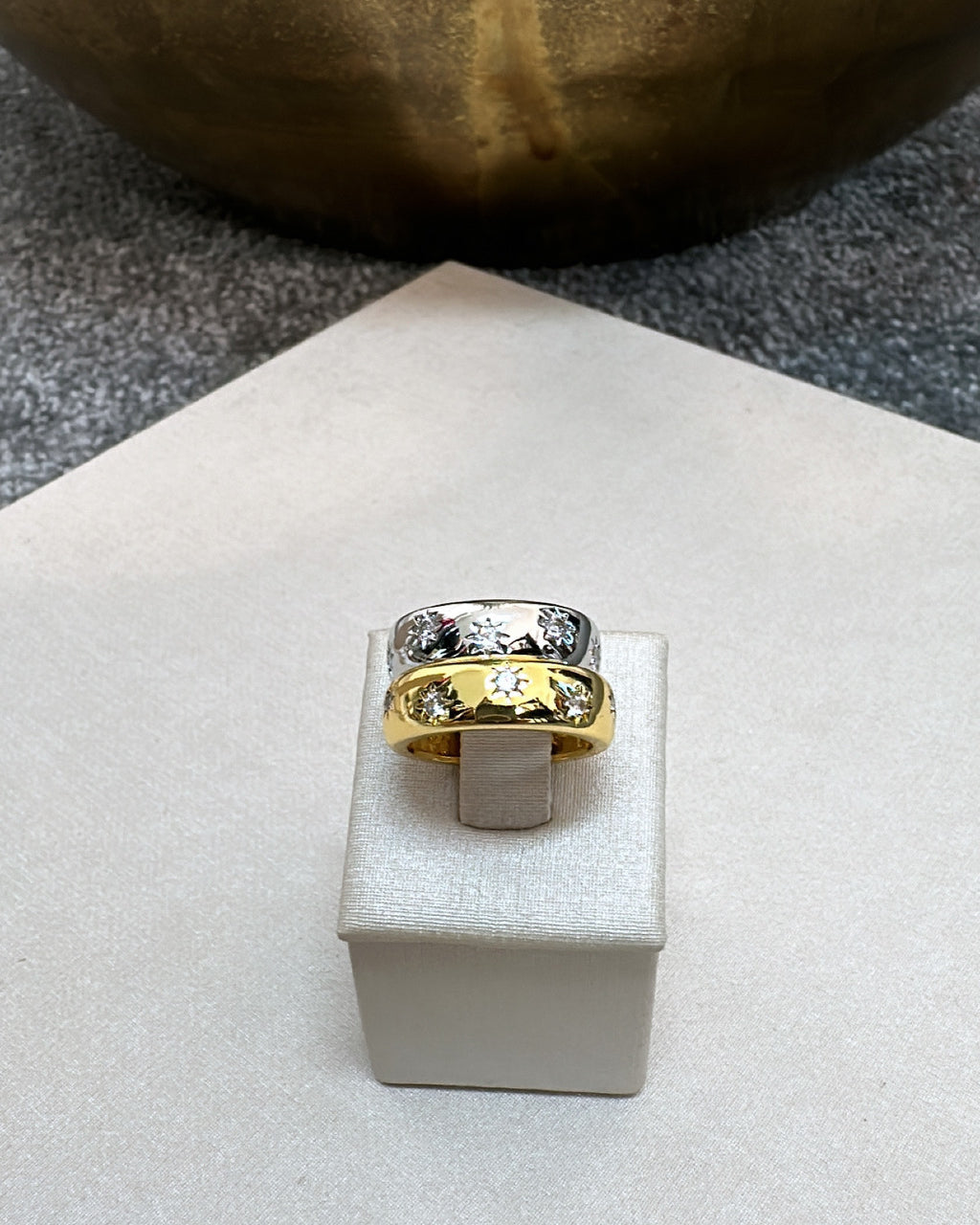Anel prateado com pedras e detalhe central dourado