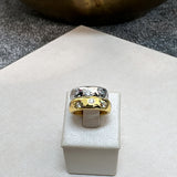 Anel prateado com pedras e detalhe central dourado